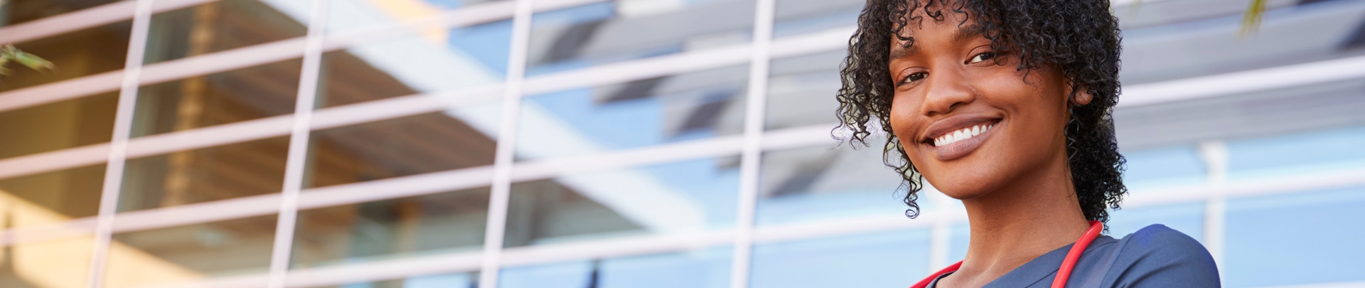 Portret van een glimlachende donkere vrouwelijke zorgverlener buiten